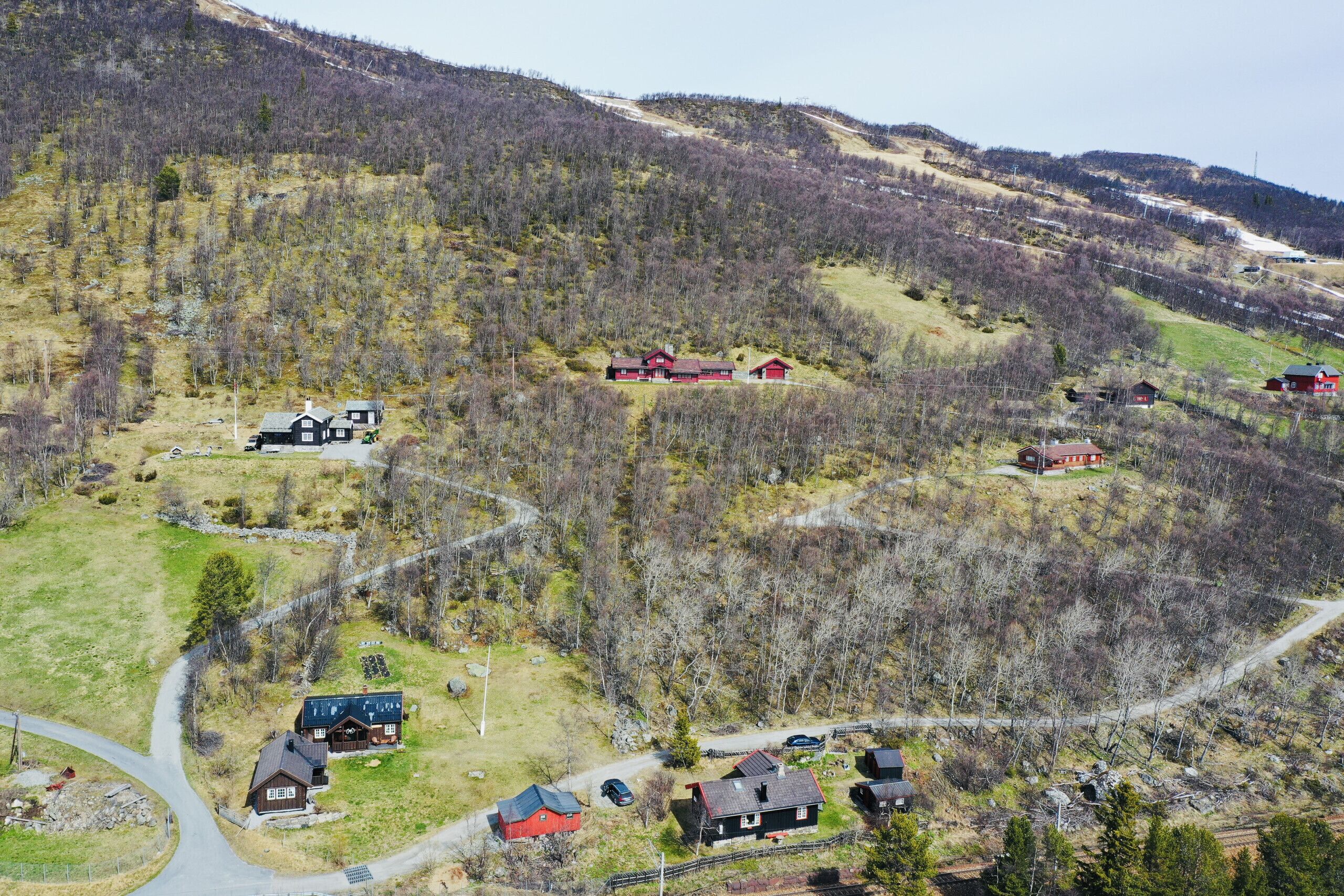 A rural landscape with multiple houses, roads, and a winding path.