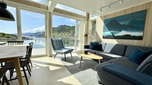 A modern interior with a dining area, a sofa, and a painting.