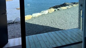 Un interior moderno con un gran ventanal que da a una vista de la playa.