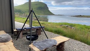 A wooden deck with a swing, a bench, and a stone table. - Magic views and walking distance to best beaches (Vestvågøy)