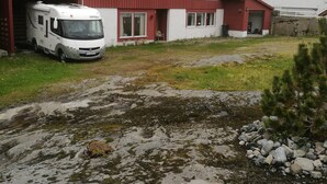 Un bâtiment rouge à deux étages, avec un camion blanc garé devant.