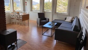 A cozy cabin with a dining area, sofa, and a small table.