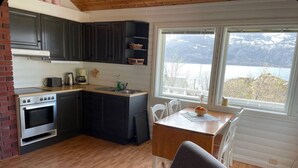 A compact kitchen with a stove, sink, and dining area.
