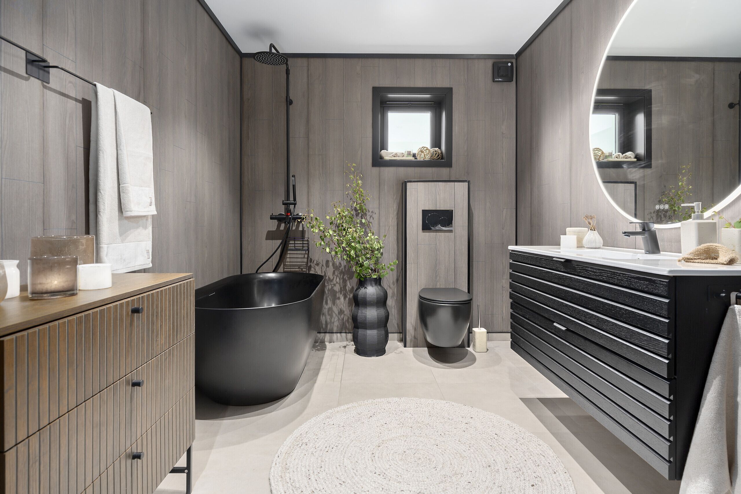 A modern bathroom with a large bathtub, a vanity with a mirror, and a wooden cabinet.