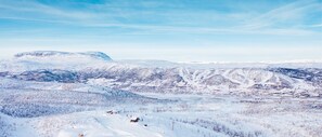 Paisaje montañoso cubierto de nieve con una estación de esquí.
