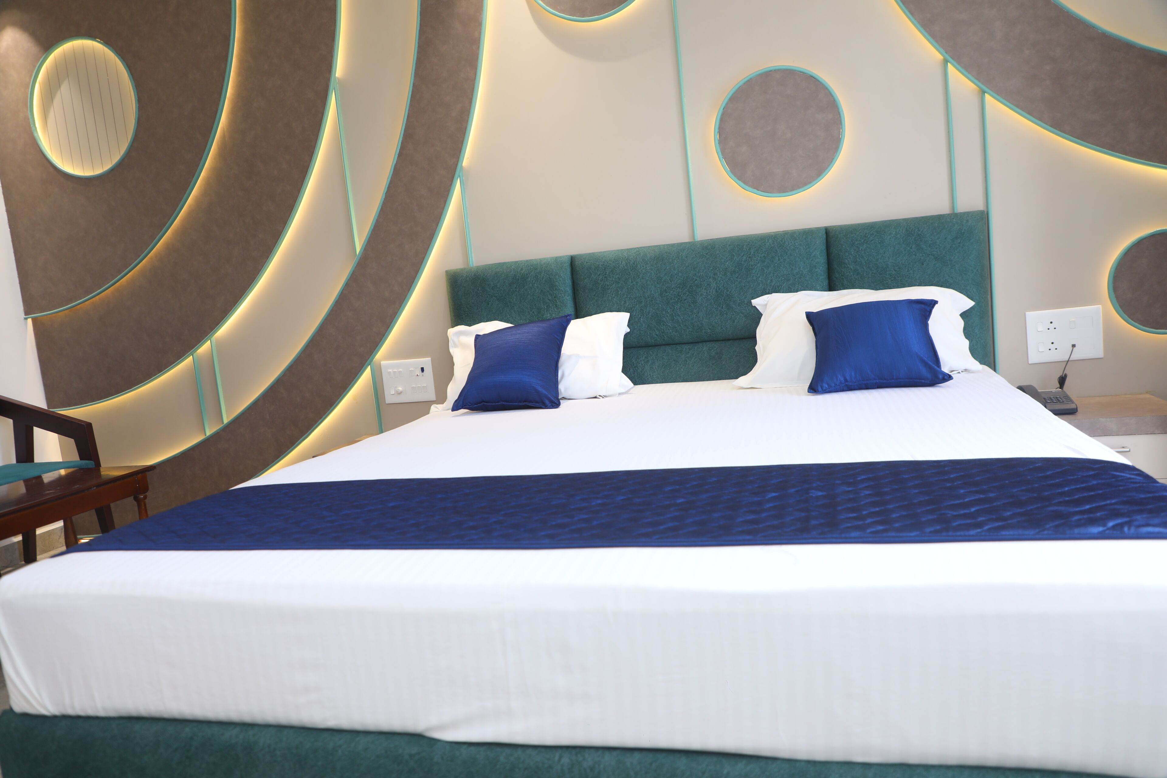 Een moderne hotelkamer met een groot bed, een hoofdeinde en een nachtkastje.