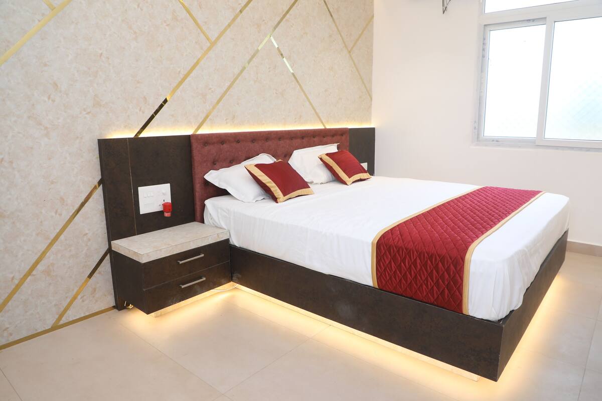 A modern bedroom with a bed, bedside tables, and a nightstand.