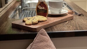 Una encimera de cocina con una taza de café, un tarro de miel y galletas.