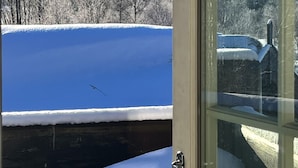 A snowy landscape with a mountain and trees visible through a glass door. - Geilo centrum - cozy apartment - central location (Hol)