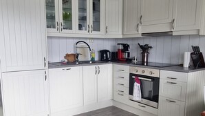Une cuisine avec des armoires blanches, une cuisinière et un évier.