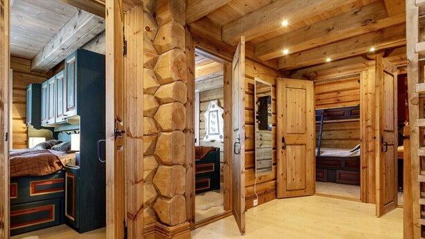 Un intérieur en bois avec un lit, des placards et un mur en pierre.
