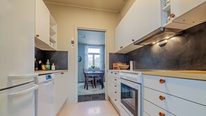A kitchen with white cabinets, a built-in oven, and a microwave.