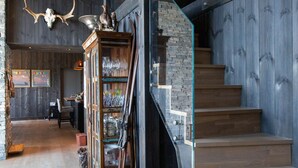 Un interno moderno con una scala, parquet e ringhiera in vetro.