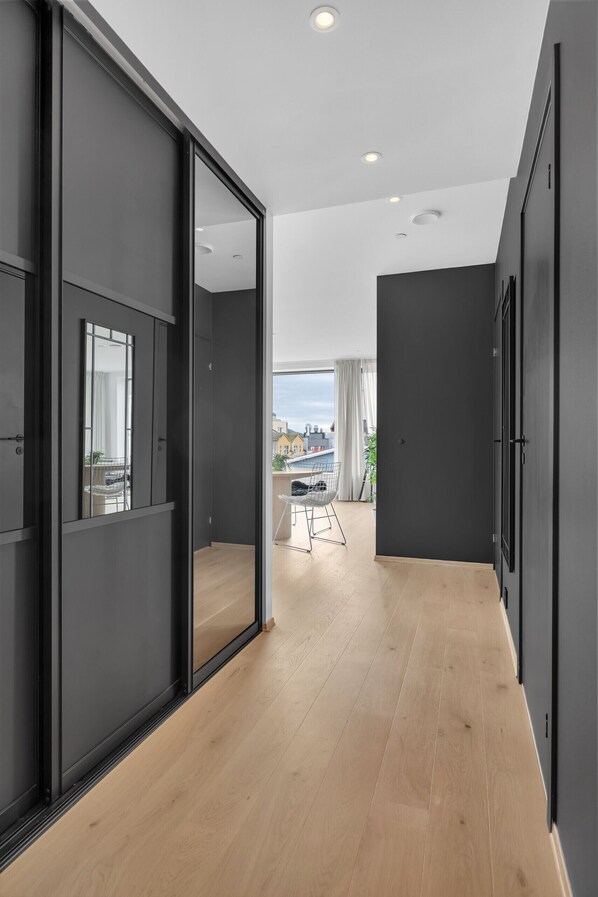 Ein modernes Interieur mit Holzboden, dunklen Wänden und Blick auf einen Außenbalkon.