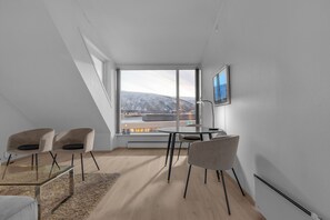 Een moderne kamer met een groot raam, een tafel en twee stoelen.