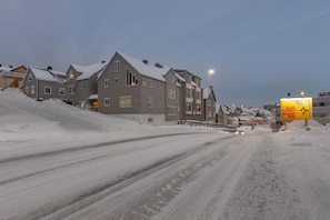 Een woonwijk met sneeuwbedekte straten en huizen.