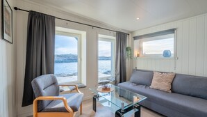 A modern living room with a sofa, armchair, and glass coffee table.