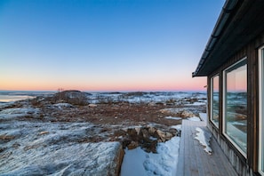 A wooden deck with a view of a rocky landscape and a body of water.