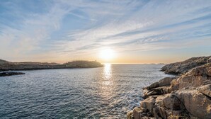 A coastal landscape with rocky terrain and calm sea.