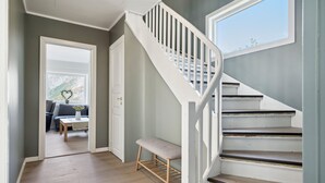 A staircase with white railings and a wooden bench at the bottom.