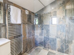 A modern bathroom with a glass shower enclosure, a towel rack, and a marble-tiled wall. - Orcaber Farmhouse (Lancaster)