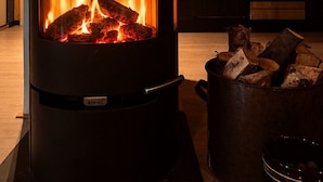 A modern kitchen with a wood-burning stove, a stove top oven, and a chimney. - Charming mountain retreat in Sudndalen (Hol)