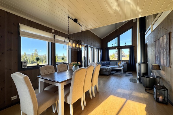 Inviting living room with a comfortable large sectional sofa and cozy fireplace, flat-screen TV and dining area.