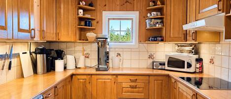 A kitchen with wooden cabinets, a coffee maker, a microwave, and a dishwasher.