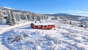 A snow-covered landscape with a red cabin and a clear sky.