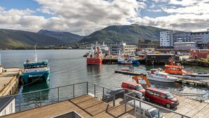 A harbor with boats, a dock, and a mountainous backdrop. - Central apartment with seaview, Tromsø (Tromsø)