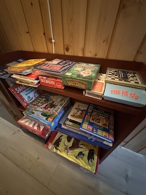 A wooden shelf with various board games and books.