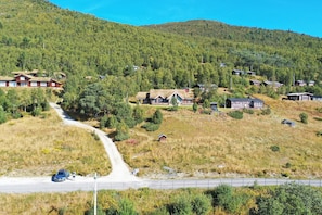 A rural village with houses on a hillside, a road, and a car.