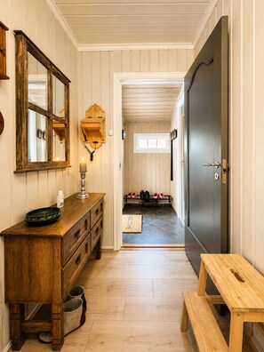 A wooden interior with a dresser, a bench, a door, and a mirror. - Fjellro-Geilo Cabin Retreat (Hol)