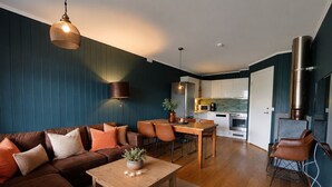 A modern living room with a sofa, coffee table, and dining area. - Ski in/Ski out and Perfect for Families (Hemsedal)