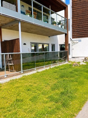 A modern two-story building with a balcony, a ladder, and a grassy yard. - Apartment in the Center of Geilo (Hol)