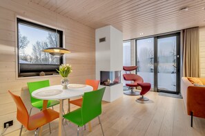 Ein modernes Interieur mit Essbereich, Kamin und Balkon mit Aussicht.