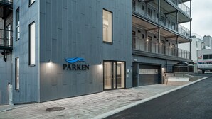 A modern building with a 'PARKEN' sign, a gated entrance, and a visible parking area. - Aurora View Apartment Svolvær (Vågan)