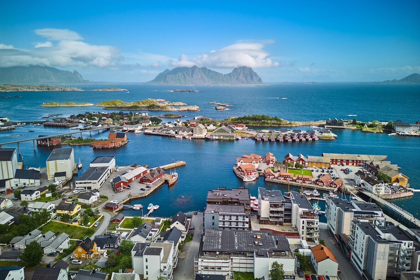 A coastal town with a harbor, buildings, and a mountain in the background.