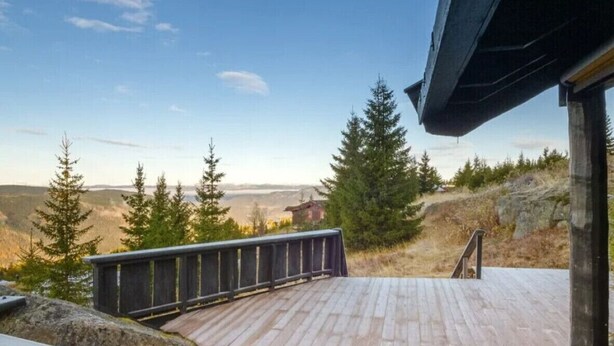 Une terrasse en bois offrant une vue sur un paysage montagneux.