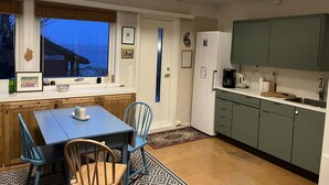 Una cocina compacta con comedor, ventana con vistas y puerta que da a otra habitación.