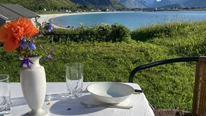 Una mesa al aire libre con vista a la playa y montañas.