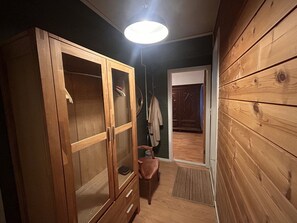 A wooden wardrobe with glass doors, a bench, a coat rack, and a door leading to another room. - City apartment in Bergen (Bergen)