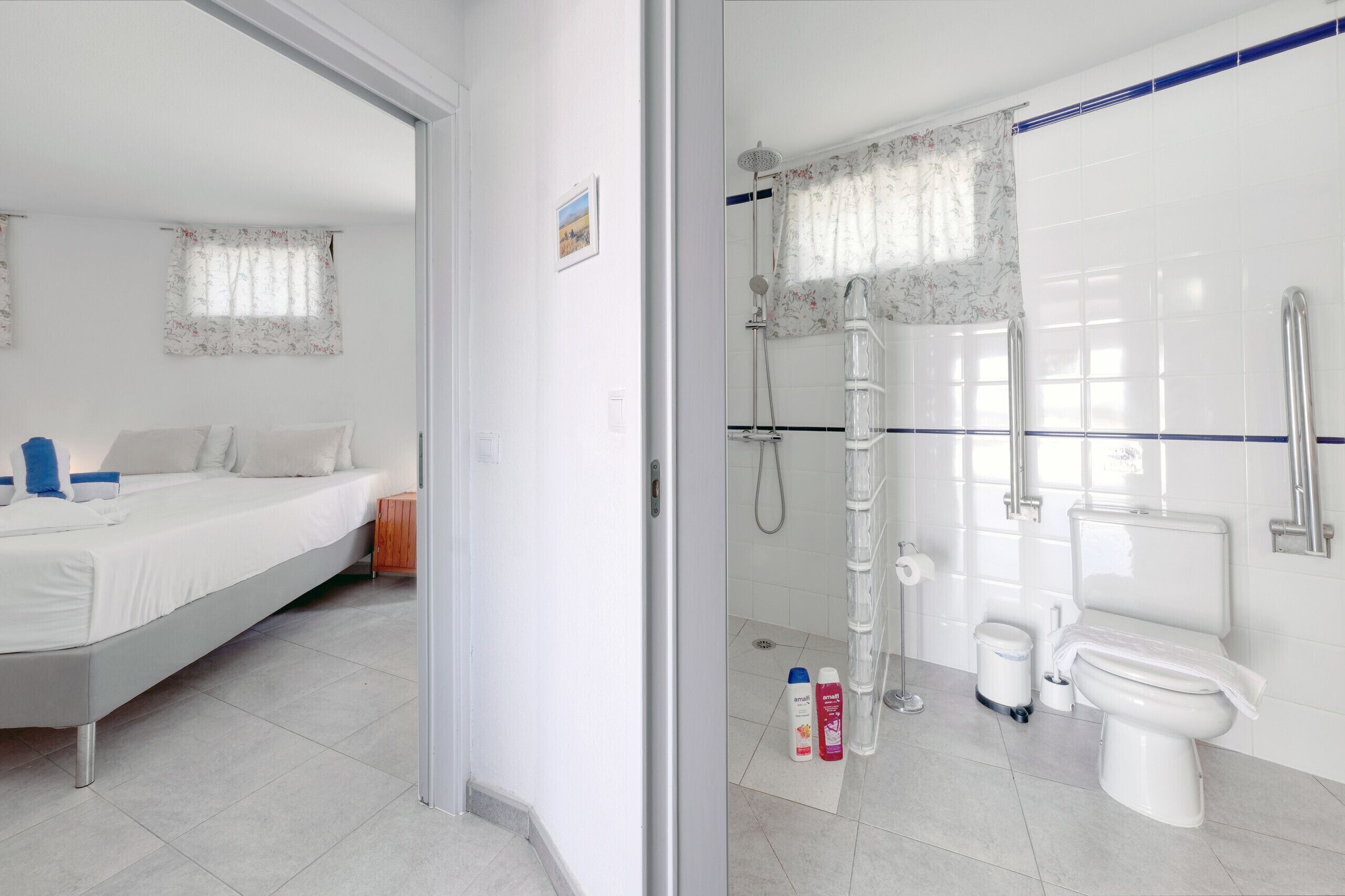 Une chambre à coucher avec un lit, une salle de bain avec une douche, des toilettes et un lavabo.