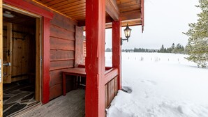 Une cabane en bois avec un banc et une porte donnant sur l’intérieur.