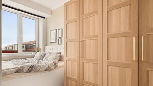 Ein Schlafzimmer mit einem Bett, einem Fenster und einem Kleiderschrank.