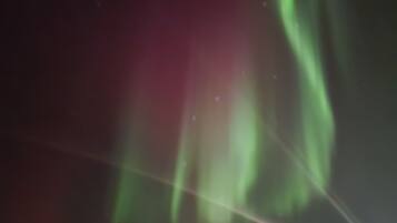 Cielo nocturno con luces de aurora verdes.