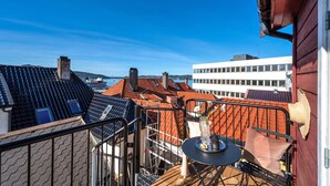 Una terrazza sul tetto con vista sulla città, un tavolo con un vaso e una ringhiera.