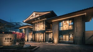 A Courtyard Hotel with a modern architectural design, featuring large windows and a well-lit entrance.