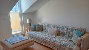 A modern living room with a sofa, a small table, and a lamp. - COMFY & COZY, in the heart of Chiavari, cozy two-room special and perfect" (Chiavari)