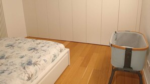 A bedroom with a bed, a wardrobe, and a storage unit. - COMFY & COZY, in the heart of Chiavari, cozy two-room special and perfect" (Chiavari)